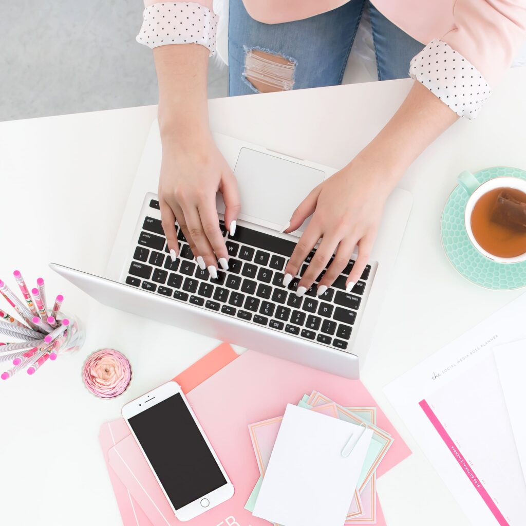 Person typing on laptop while brainstorming authentic website copywriting ideas for small business